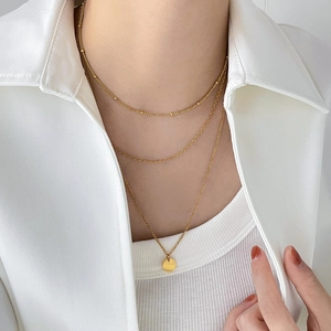 Collier doré à trois rangs avec chaîne satellite et pendentif rond minimaliste chic