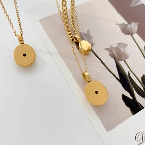 Detail of gold circular pendant necklaces featuring delicate and cuban chain styles