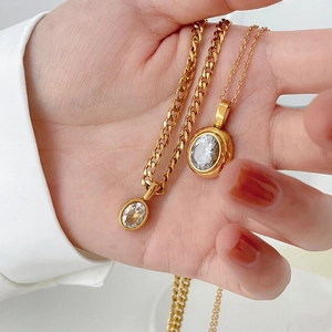 Gold oval sapphire pendant necklace and classic cubic zirconia necklace set on model hand