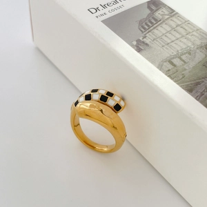 Detalle macro del anillo vintage dorado con diseño de esmalte de tablero de ajedrez