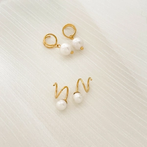 Elegant gold hoop earrings with white teardrop pearls and spiral screw-back designs