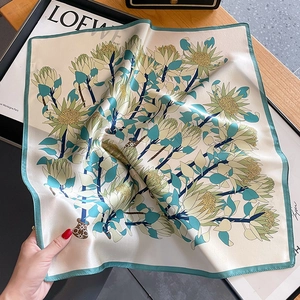 Carré de soie aux motifs floraux et bordure verte pour un look féminin et élégant
