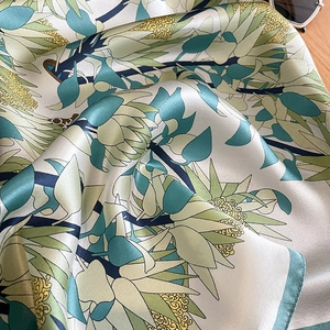 Gros plan du foulard en soie avec motifs de protéa et bords roulés délicats