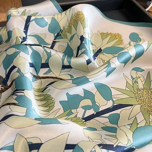 Détail d'un foulard en soie avec motifs floraux et texture satinée lisse et brillante
