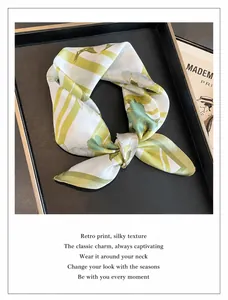 Detalle de un pañuelo cuadrado de seda con motivos florales vintage en caja de regalo