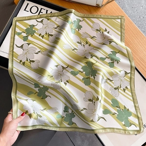 Elegante pañuelo de seda con estampado de magnolia y rayas verdes en mesa de madera