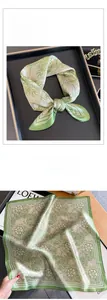 Detailed view of floral silk scarf featuring elegant green and white botanical patterns