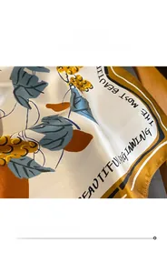 Close-up of silk square scarf featuring elegant floral prints and fine stitched edges