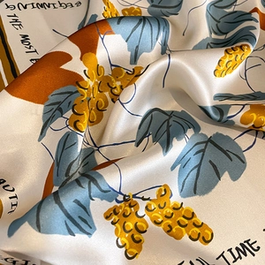 Detail of silk scarf showing smooth satin texture and autumn botanical prints