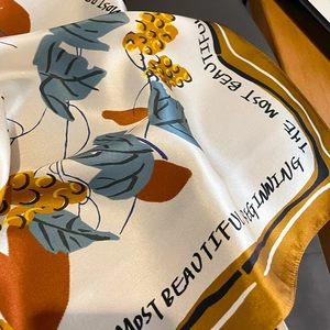 Detail of silk scarf showing floral print and the text THE MOST BEAUTIFUL BEGINNING