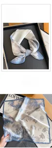 Detailed view of silk square scarf featuring vintage floral print and blue hem detail