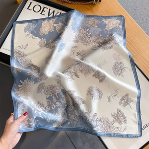 Floral silk square scarf with blue and white daisy print in a luxury lifestyle setting