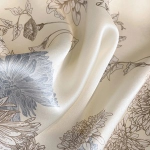 Macro shot of elegant floral silk scarf showing premium texture and soft silk luster