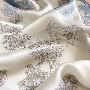 Detailed view of silk square scarf featuring delicate floral prints and smooth texture
