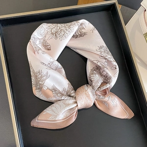 Elegant champagne silk scarf featuring vintage floral patterns displayed in a tray