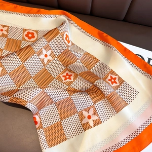 Gros plan du foulard en soie rétro à carreaux avec motifs floraux et bords oranges