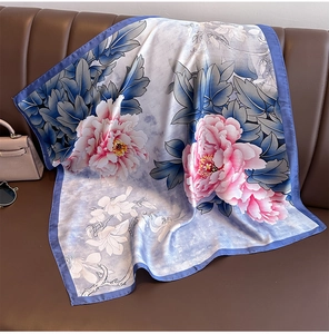 Detailed view of large blue floral silk scarf featuring pink peonies and magnolias