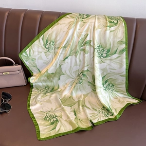 Elegant green floral square silk scarf for women displayed with fashion accessories