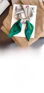 Detail of silk-like fashion scarf featuring elegant lotus floral pattern in grey-green
