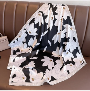 Texture détaillée d'un foulard carré en soie avec d'élégants motifs floraux blancs