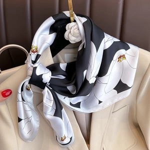 Foulard satiné élégant avec imprimé floral noir et blanc sur un blazer beige chic