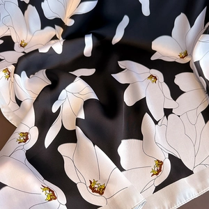 Élégant foulard en soie noire avec imprimé floral blanc et texture satinée lisse