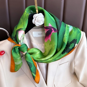 Eleganter grüner Lotus-Seidenschal mit Koi-Druck kombiniert mit einem cremefarbenen Blazer