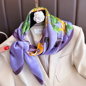 Purple silk-like square scarf with yellow floral and bird prints on a white blazer