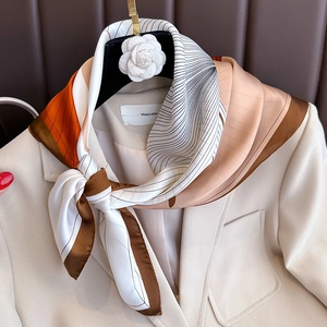 Minimalist geometric color-block satin scarf styled on a blazer for a chic fall look