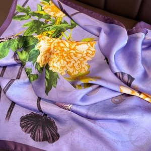 Elegant lavender silk scarf with yellow floral print and a smooth glossy texture
