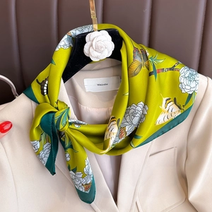 Elegante foulard in seta verde brillante con stampa floreale e farfalle su un blazer