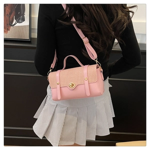 Dettaglio borsa vintage da donna in pelle rosa e trama intrecciata indossata a spalla