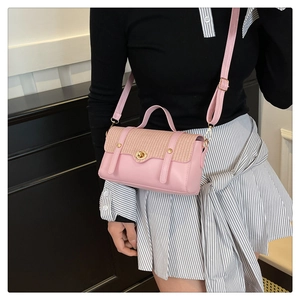 Borsa da donna in pelle rosa e tessuto intrecciato indossata con tracolla regolabile