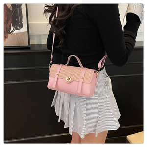 Vista posteriore di una modella con borsa a tracolla intrecciata rosa chiaro e chiusura