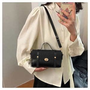 Dettaglio della borsa vintage in pelle nera e intrecciata con chiusura a scatto e borchie