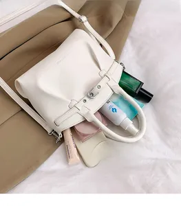 Top view of white lychee leather bucket bag showing spacious interior with daily essentials