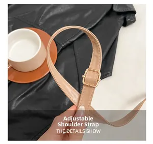 Detail of adjustable leather strap with golden metal buckle and fine stitching