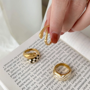 Detalle de anillos dorados vintage con esmalte de tablero y motivos de serpiente