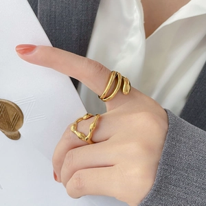 Λεπτομερής όψη δύο χρυσών δαχτυλιδιών σε στυλ λάβας με οργανικές ρέουσες γραμμές