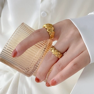 Conjunto de anillos dorados acolchados y trenzados usados con un vaso