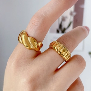 Detalle de anillos dorados estilo croissant y anillos con textura en los dedos
