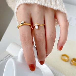 18K gold plated titanium rings set with square and teardrop zircon on a model's hand