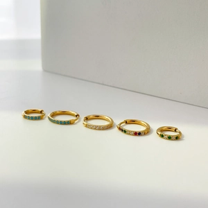 Detailed shot of five gold hoops with colorful zircon stones in various sizes