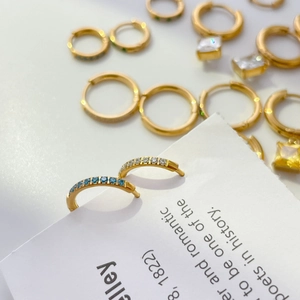 Gold hoop earrings featuring channel-set blue and clear cubic zirconia stones