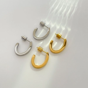 Polished gold and silver C-shaped chunky hoop earrings with mirror finish in 45-degree view