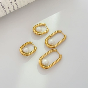 Detail of gold U-shaped pearl earrings in two sizes shown from a 45-degree angle