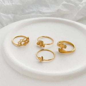Set of four gold 18K plated rings featuring bee, butterfly, lotus, and hugging hands designs
