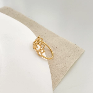 Detailed view of hollow lotus flower ring in 18K gold plated titanium steel finish