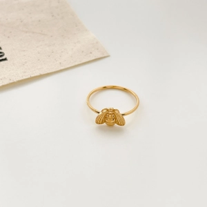 Macro view of 18K gold plated ring featuring a detailed small honeybee design on a slim band