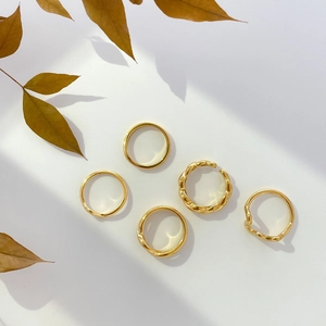 Détail du lot de 5 bagues dorées minimalistes aux designs torsadés et vagues irrégulières